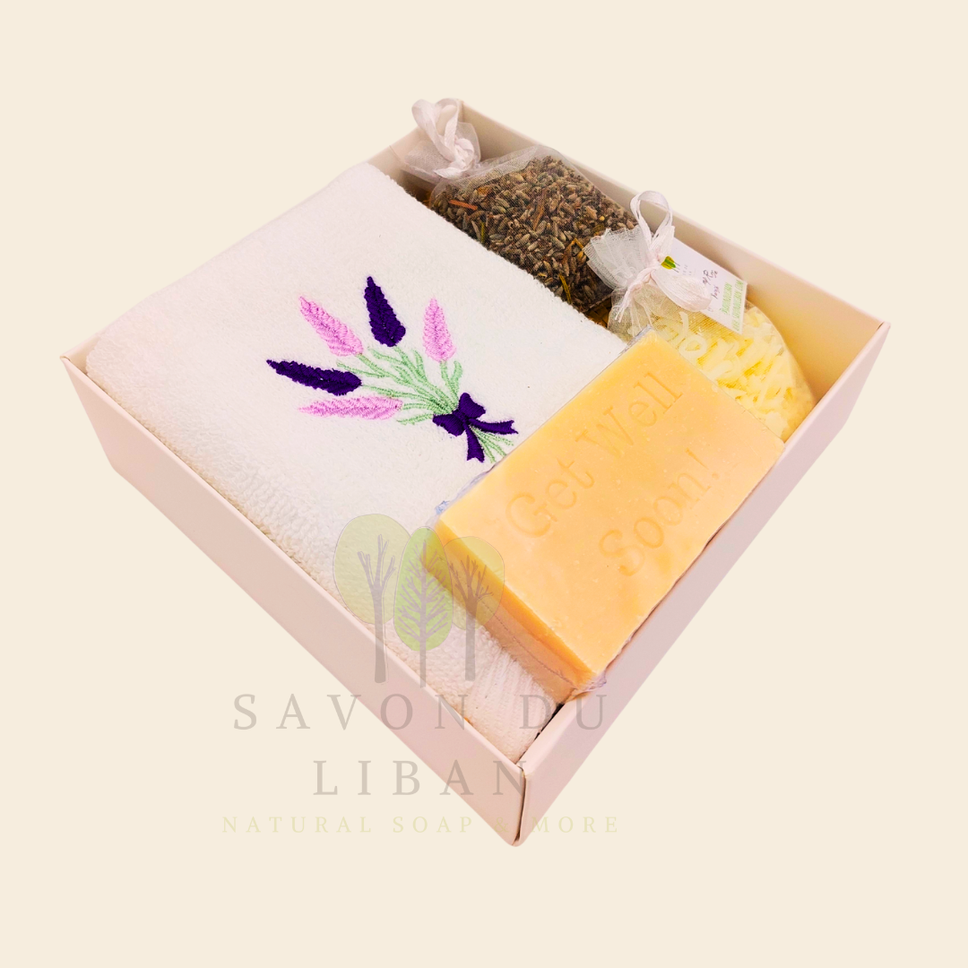 Lavender Breeze Get Well Soon Gift Box, with Lavender embroidered towel, a musk soap engraved Get Well Soap, a lavender buds bag and a grated soap bag, all in a 16x16x5 cm box with transparent lid. Handmade by Savon Du Liban.