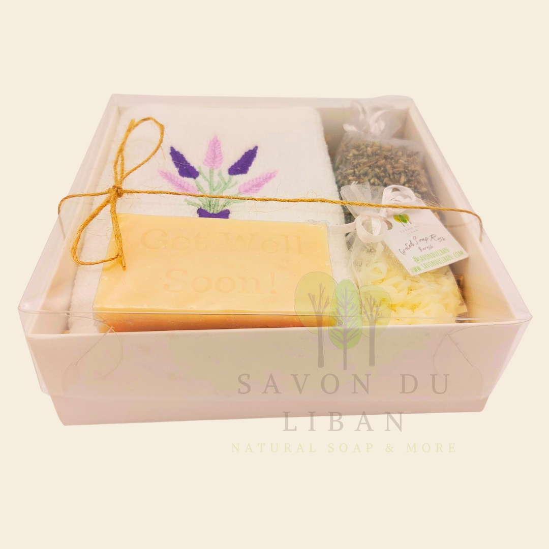 Lavender Breeze Get Well Soon Gift Box, with Lavender embroidered towel, a musk soap engraved Get Well Soap, a lavender buds bag and a grated soap bag, all in a 16x16x5 cm box with transparent lid. Handmade by Savon Du Liban.