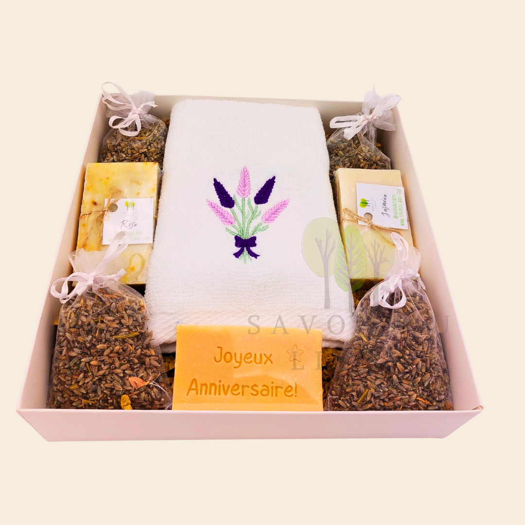 Lavender Moments birthday gift box with lavender towel, soaps, musk engraved bar, and lavender bags in a white box with transparent lid.