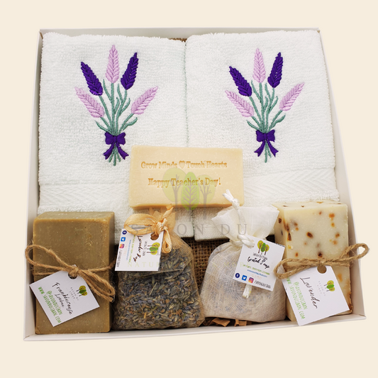 Teacher's Drop-Dead Gorgeous Gift Set with Stamped Soap 'Grow Minds ❤️ Touch Hearts - Happy Teacher's Day!', 2 Lavender Embroidered Towels, 2 soap bars, 1 lavender bag, 1 grated soap bag in a 22 x 22 x 5 cm box with transparent cover.