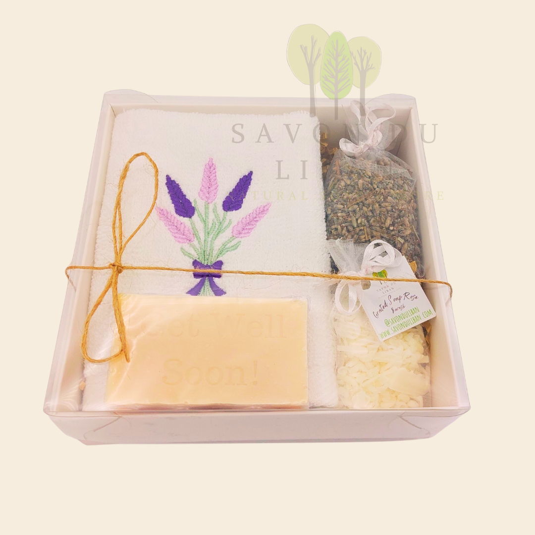 Lavender Breeze Get Well Soon Gift Box, with Lavender embroidered towel, a musk soap engraved Get Well Soap, a lavender buds bag and a grated soap bag, all in a 16x16x5 cm box with transparent lid. Handmade by Savon Du Liban.