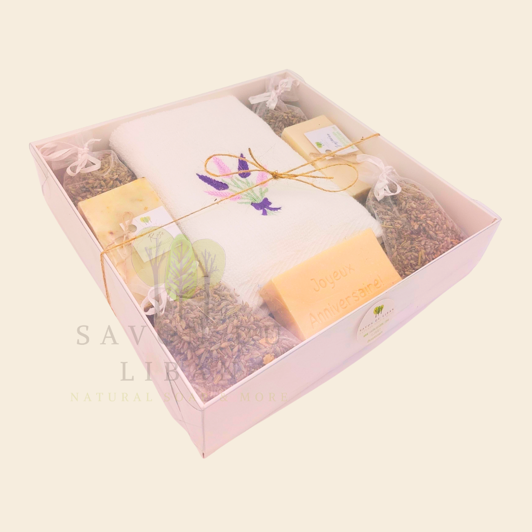 Lavender Moments birthday gift box with lavender towel, soaps, musk engraved bar, and lavender bags in a white box with transparent lid.