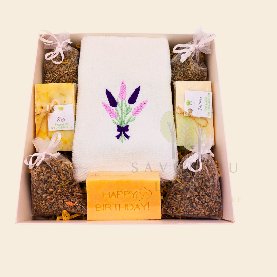 Lavender Moments birthday gift box with lavender towel, soaps, musk engraved bar, and lavender bags in a white box with transparent lid.