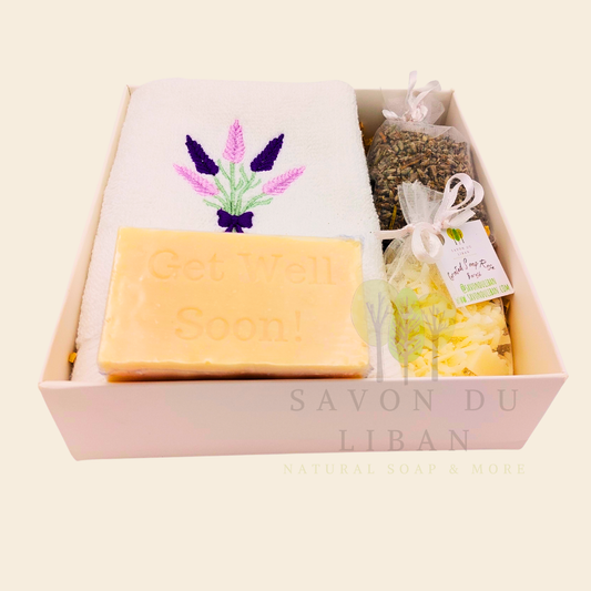 Lavender Breeze Get Well Soon Gift Box, with Lavender embroidered towel, a musk soap engraved Get Well Soap, a lavender buds bag and a grated soap bag, all in a 16x16x5 cm box with transparent lid. Handmade by Savon Du Liban.