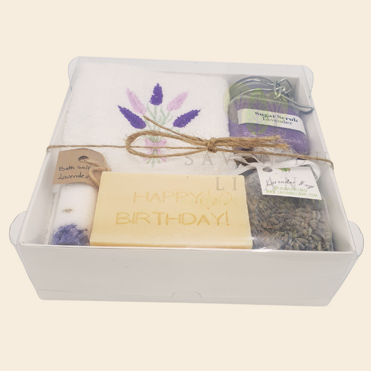 Whispers of Celebration spa set in white box: Sugar Scrub, Bath Salt, Lavender Buds, White Towel with Lavender Embroidery, Musk Soap stamped Happy Birthday