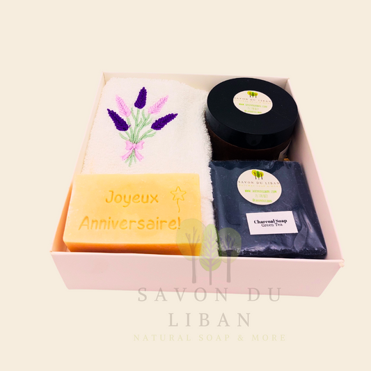 Whispers of Celebration: Birthday gift box with lavender towel, engraved soap, sugar scrub, and charcoal bar. Handmade by Savon Du Liban.