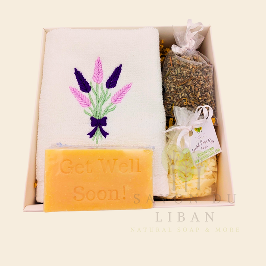 Lavender Breeze Get Well Soon Gift Box, with Lavender embroidered towel, a musk soap engraved Get Well Soap, a lavender buds bag and a grated soap bag, all in a 16x16x5 cm box with transparent lid. Handmade by Savon Du Liban.
