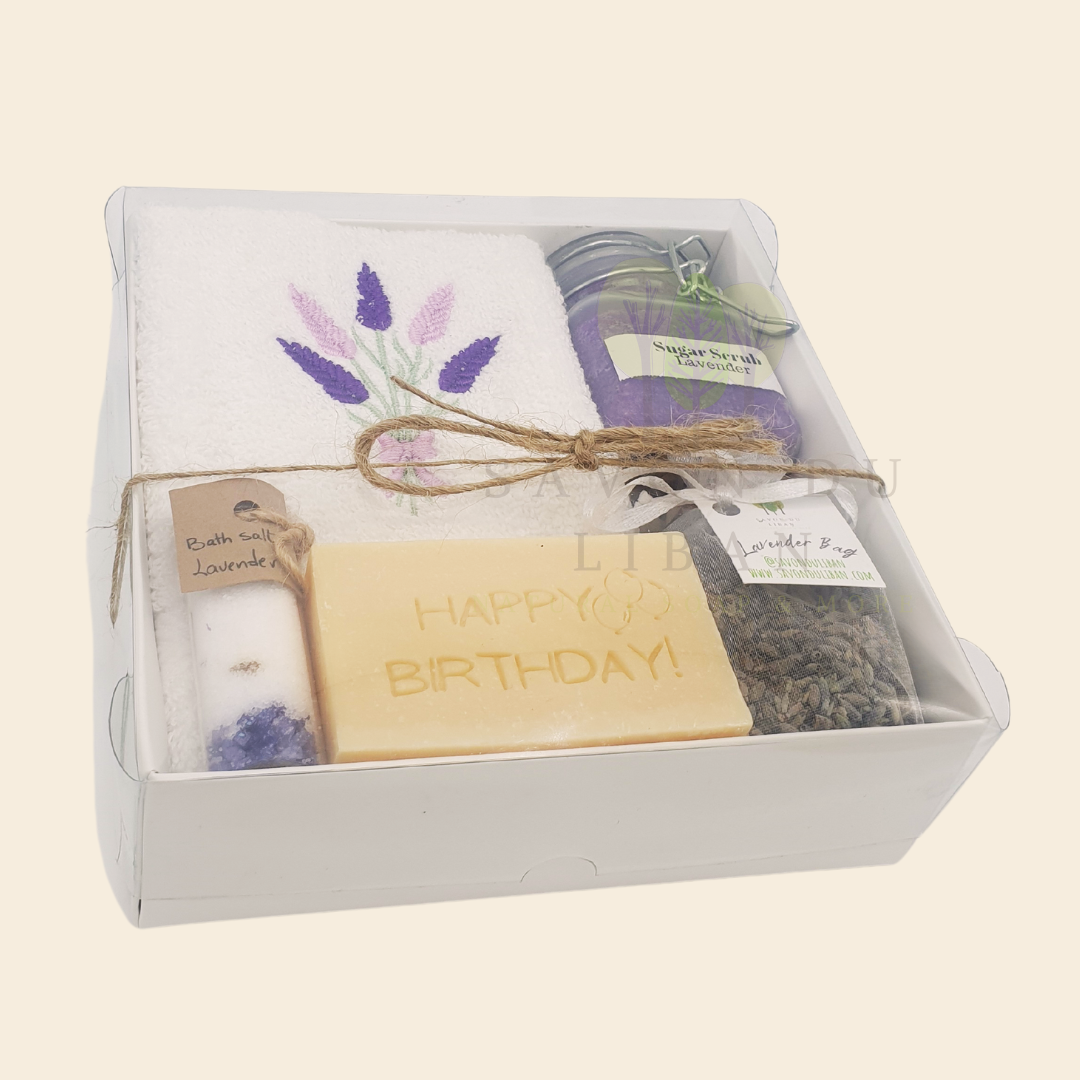 Whispers of Celebration spa set in white box: Sugar Scrub, Bath Salt, Lavender Buds, White Towel with Lavender Embroidery, Musk Soap stamped Happy Birthday