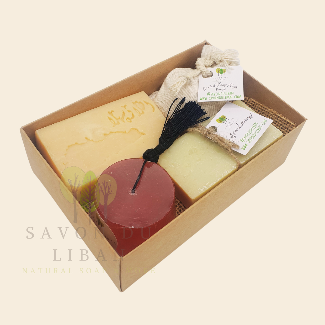 Timeless Charms of Lebanon soap gift set with grated soap, extra laurel soap bar, a tarboosh soap, and a musk soap stamped with Lebanon's Map & Ahla w Sahla in Arabic. Box with open lid.