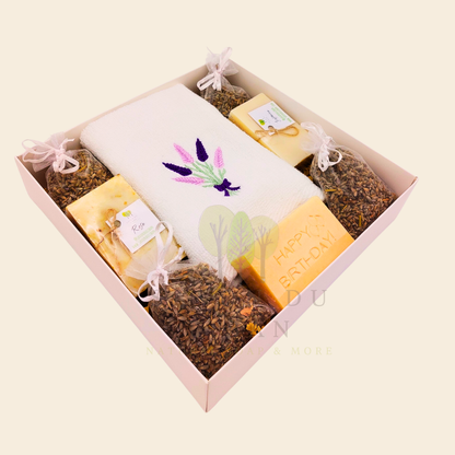 Lavender Moments birthday gift box with lavender towel, soaps, musk engraved bar, and lavender bags in a white box with transparent lid.