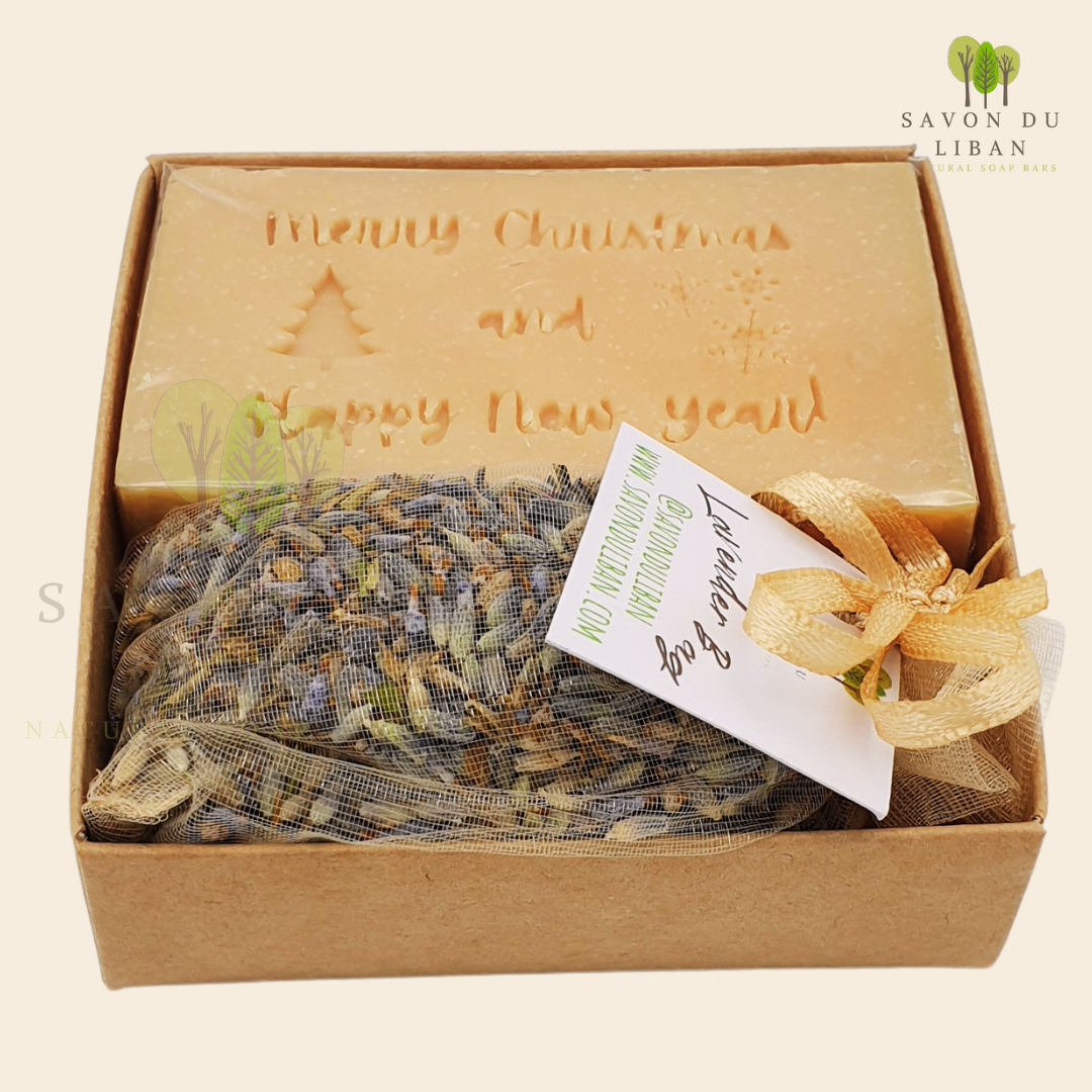 Christmas Serenity Handy Box with musk natural soap engraved with "Merry Christmas & Happy New Year" and lavender sachet, all in a 8x8x2.5 cm kraft box with transparent lid.