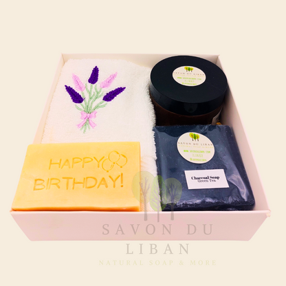 Whispers of Celebration: Birthday gift box with lavender towel, engraved soap, sugar scrub, and charcoal bar. Handmade by Savon Du Liban.