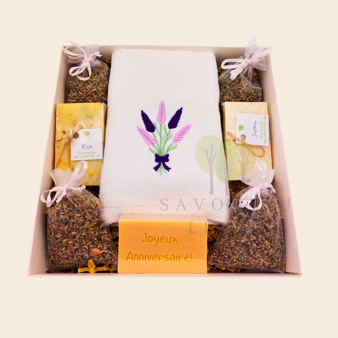 Lavender Moments birthday gift box with lavender towel, soaps, musk engraved bar, and lavender bags in a white box with transparent lid.