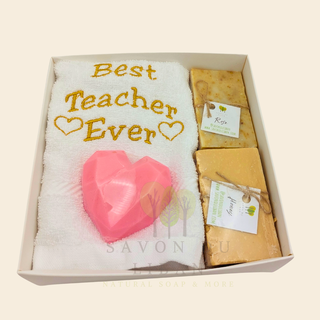 "Teacher's Fabulous Box" gift set with a 30x30 cm towel embroidered with 'Best Teacher Ever' and soaps (including a heart-shaped soap) in a box with a transparent cover. Handmade in Lebanon by Savon Du Liban for Teacher's Day.