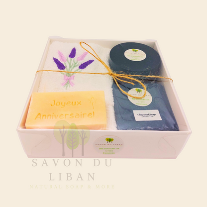 Whispers of Celebration: Birthday gift box with lavender towel, engraved soap, sugar scrub, and charcoal bar. Handmade by Savon Du Liban.