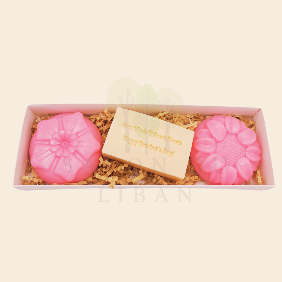 A Teacher’s Scent-sational Petals – The 2025 Teacher's Day Floral Gift Set with a Musk soap stamped 'Grow Minds ❤️ Touch Hearts - Happy Teacher's Day!' and two scented flower-shaped soaps in an elegant 23x8x3.5 cm box with transparent cover.