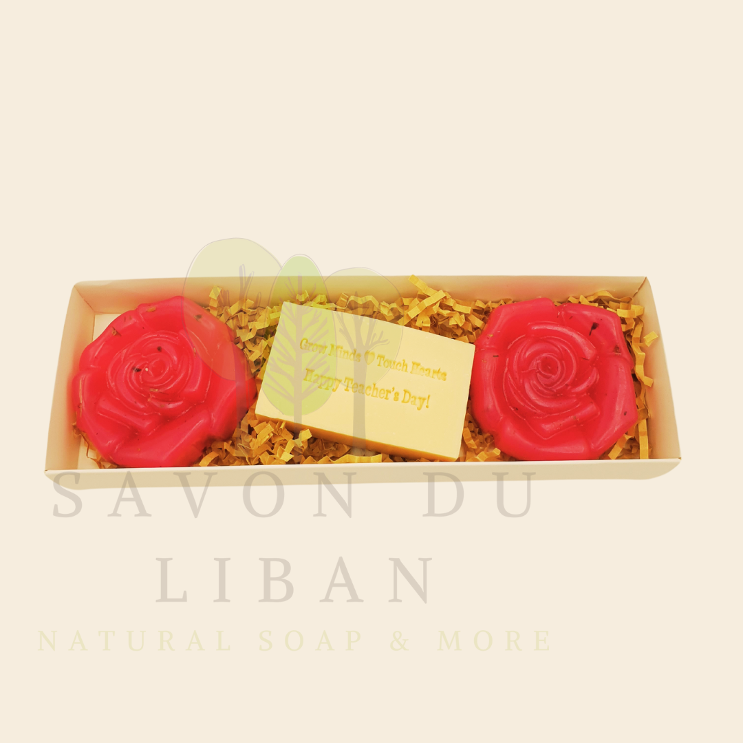 A Teacher’s Scent-sational Petals – The 2025 Teacher's Day Floral Gift Set with a Musk soap stamped 'Grow Minds ❤️ Touch Hearts - Happy Teacher's Day!' and two scented flower-shaped soaps in an elegant 23x8x3.5 cm box with transparent cover.