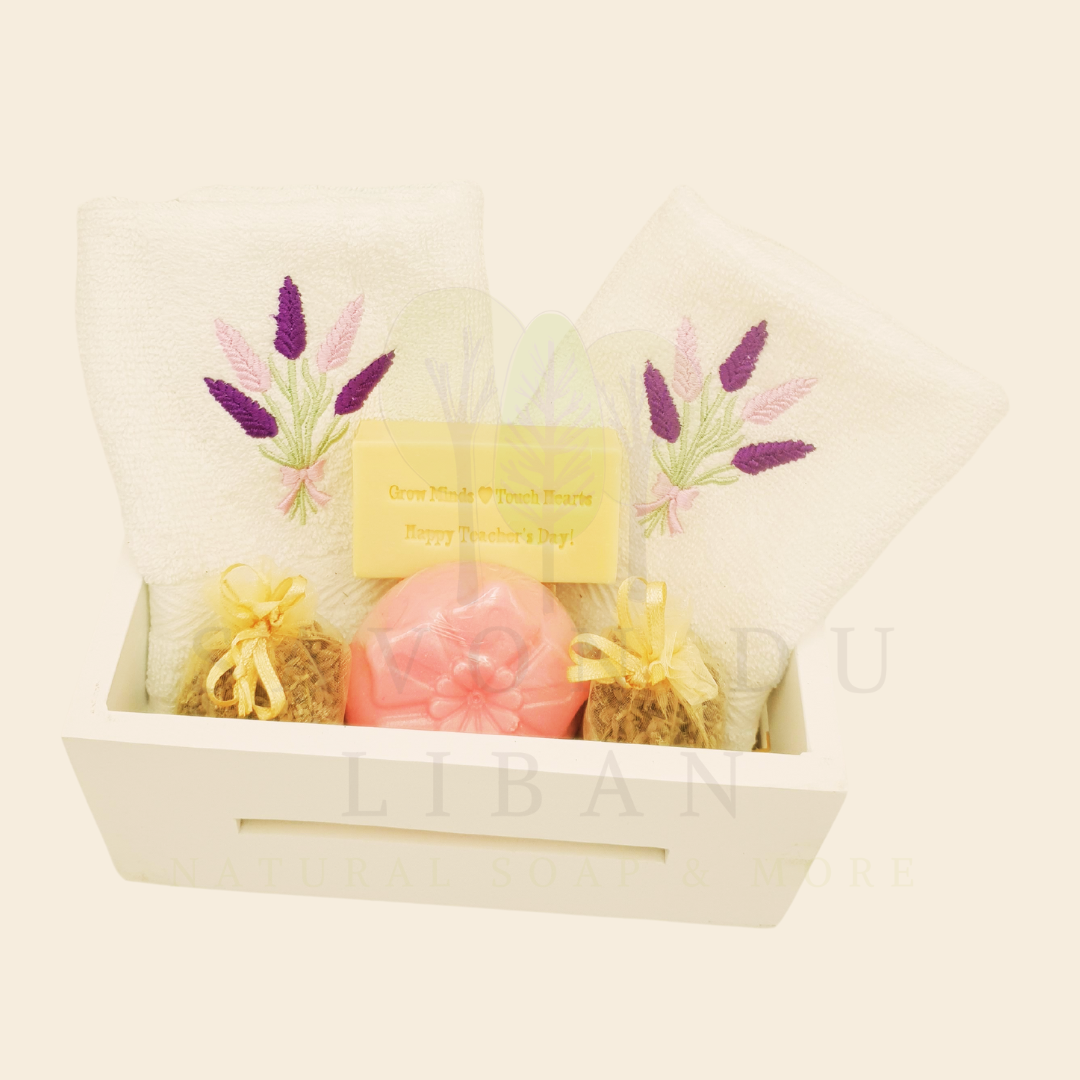 Blooming Minds Gift Basket, a wooden basket (20x12x9 cm) with 2 lavender-embroidered towels, a flower soap, a musk soap stamped with “Grow Minds ❤️ Touch Hearts - Happy Teacher's Day!” and 2 lavender buds bags.