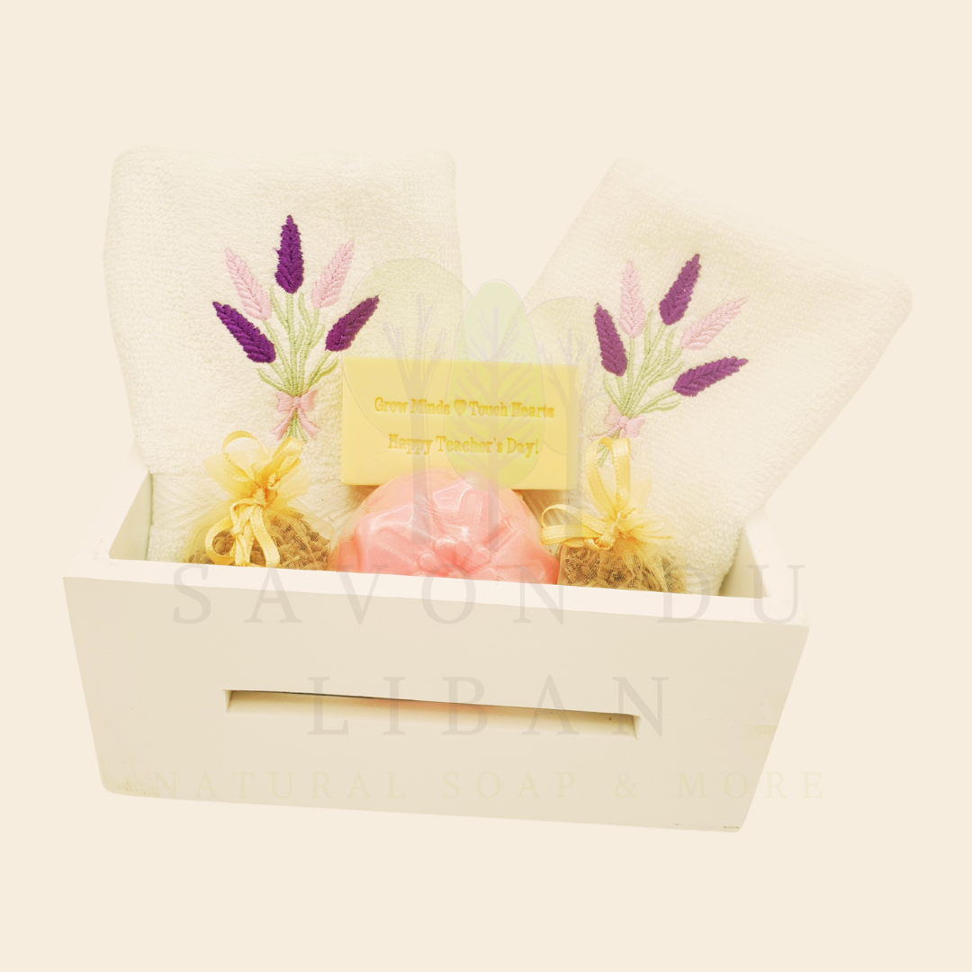 Blooming Minds Gift Basket, a wooden basket (20x12x9 cm) with 2 lavender-embroidered towels, a flower soap, a musk soap stamped with “Grow Minds ❤️ Touch Hearts - Happy Teacher's Day!” and 2 lavender buds bags.