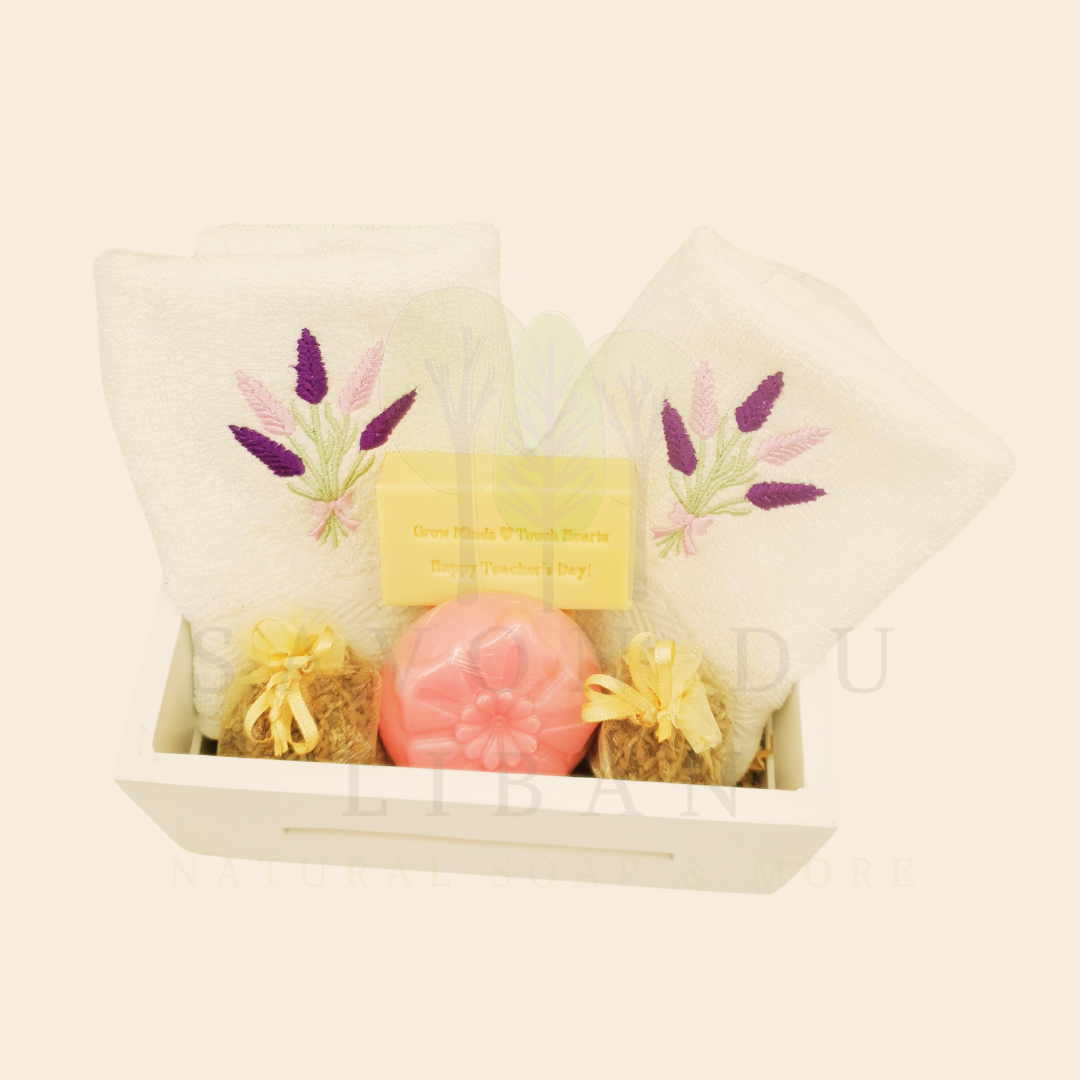 Blooming Minds Gift Basket, a wooden basket (20x12x9 cm) with 2 lavender-embroidered towels, a flower soap, a musk soap stamped with “Grow Minds ❤️ Touch Hearts - Happy Teacher's Day!” and 2 lavender buds bags.