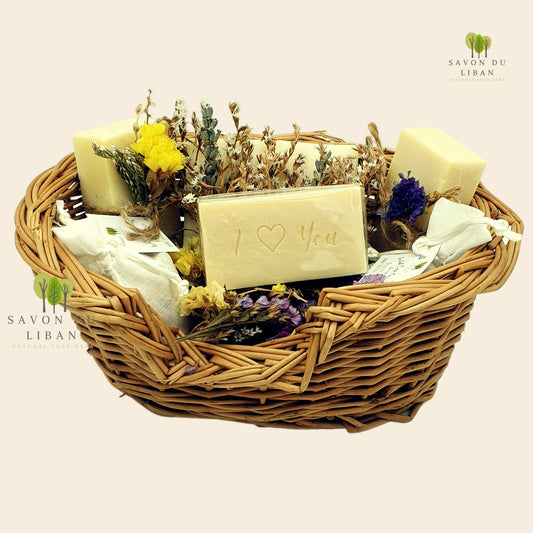 Floral Whisper Gift Set with four soap bars decorated with dried flowers, two bags of grated soap, and Musk soap stamped ‘I Love You’ in a straw basket.