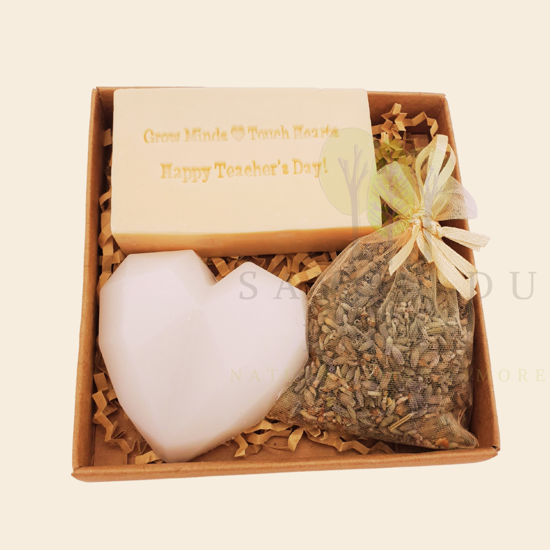 Teacher’s Relax & Enjoy Set – Stamped soap 'Grow Minds ❤️ Touch Hearts - Happy Teacher's Day!', heart soap, and lavender bag in a 11x11x2.5 cm craft box with transparent cover.